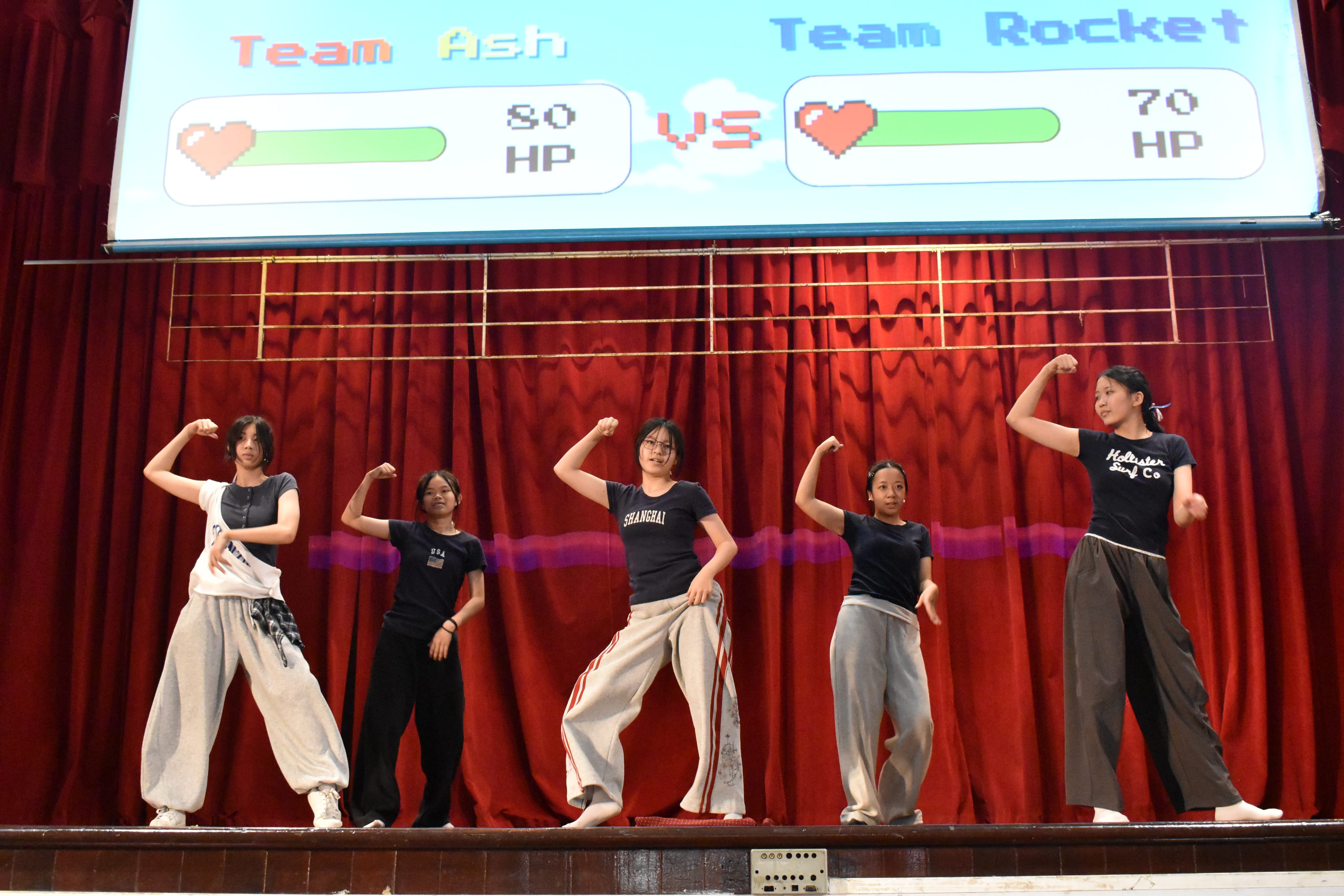 5 students dancing on stage.